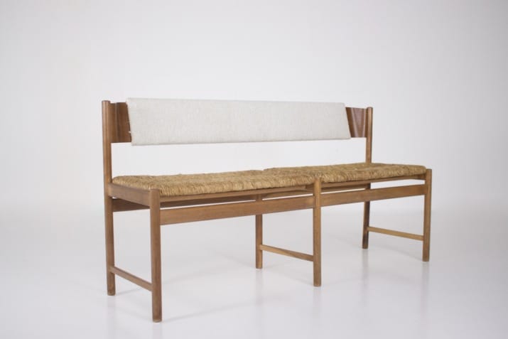 Modernist bench, straw-covered seat.